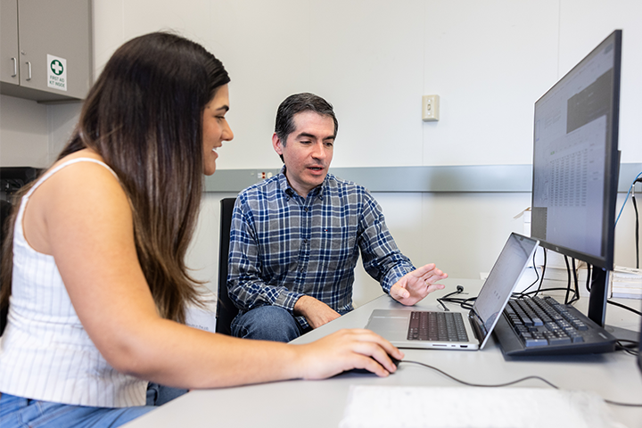 LMU engineering professor talking with female graduate student looking at laptop